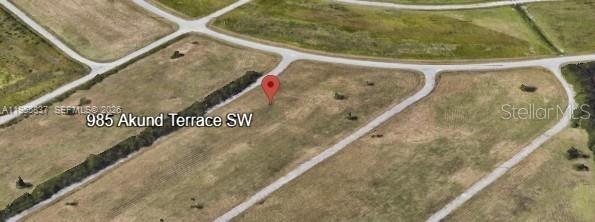 An aerial map view shows a vacant, grassy residential lot marked with a red pin — 985 AKUND TER SW, Palm Bay FL 32908, PALM BAY, FL