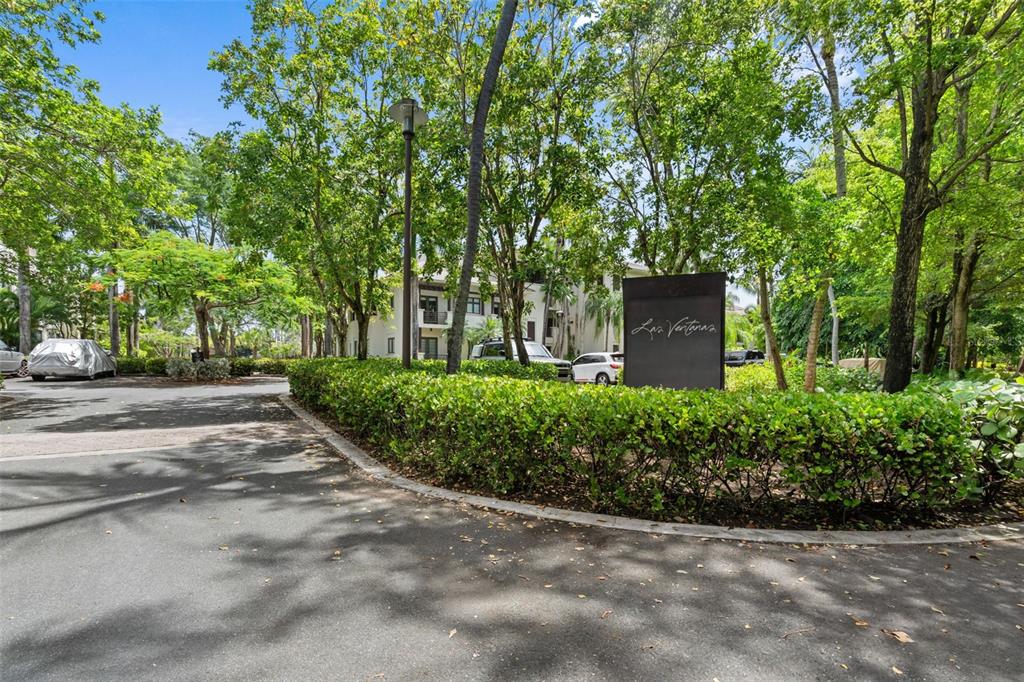 A sign for Las Ventanas stands behind a manicured hedge in a tree-lined parking area — Bahia Beach Resort LAS VENTANAS II UNIT 104, RIO GRANDE, PR
