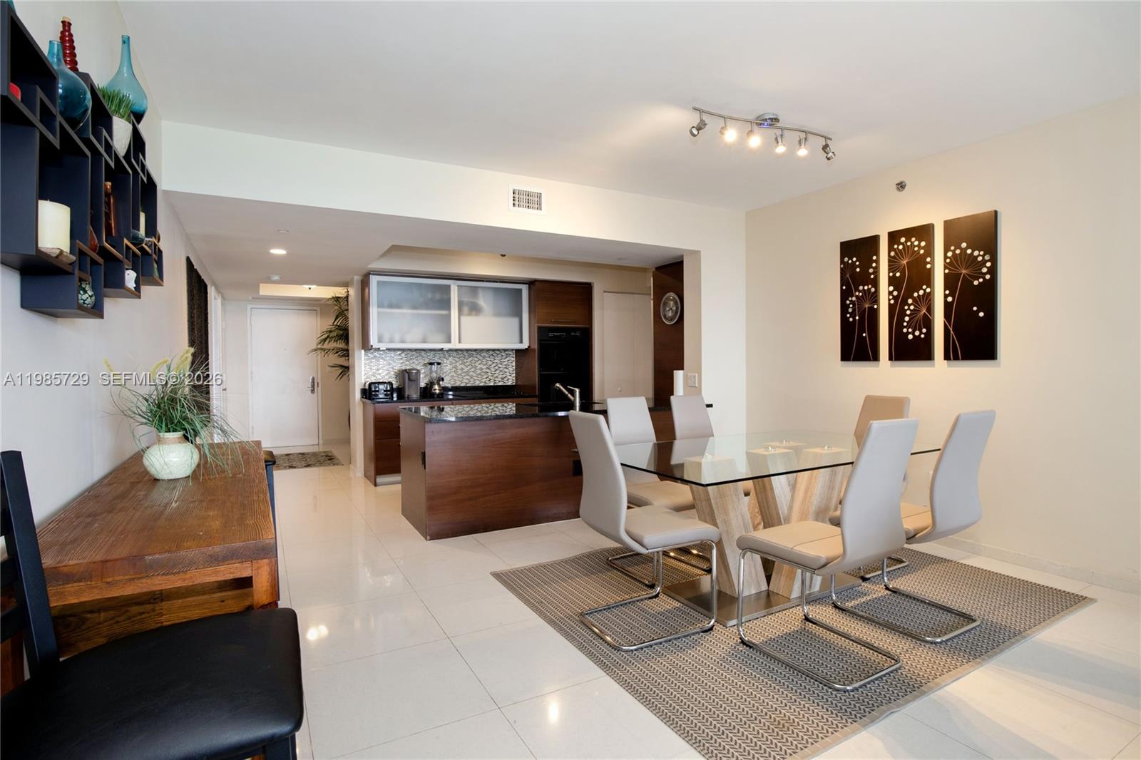 A dining area with a glass table and chairs sits adjacent to a modern kitchen — 1830 S OCEAN DR # 3204, Hallandale Beach FL 33009, HALLANDALE BEACH, FL