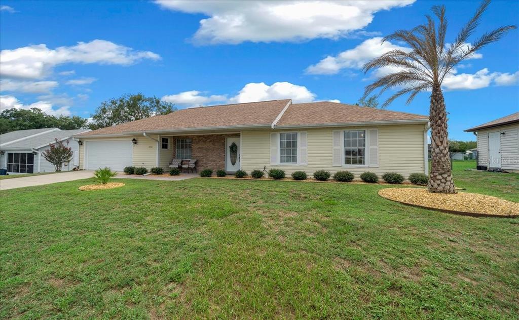 A single-story house with light yellow siding, a brick entryway, and a palm tree — 4504 NW 32ND STREET, OCALA, FL