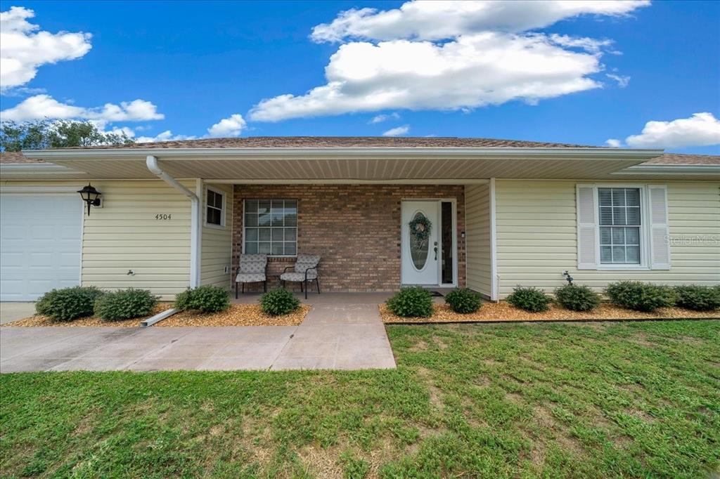 A single-story house with light yellow siding, a brick entryway, and a concrete walkway — 4504 NW 32ND STREET, OCALA, FL