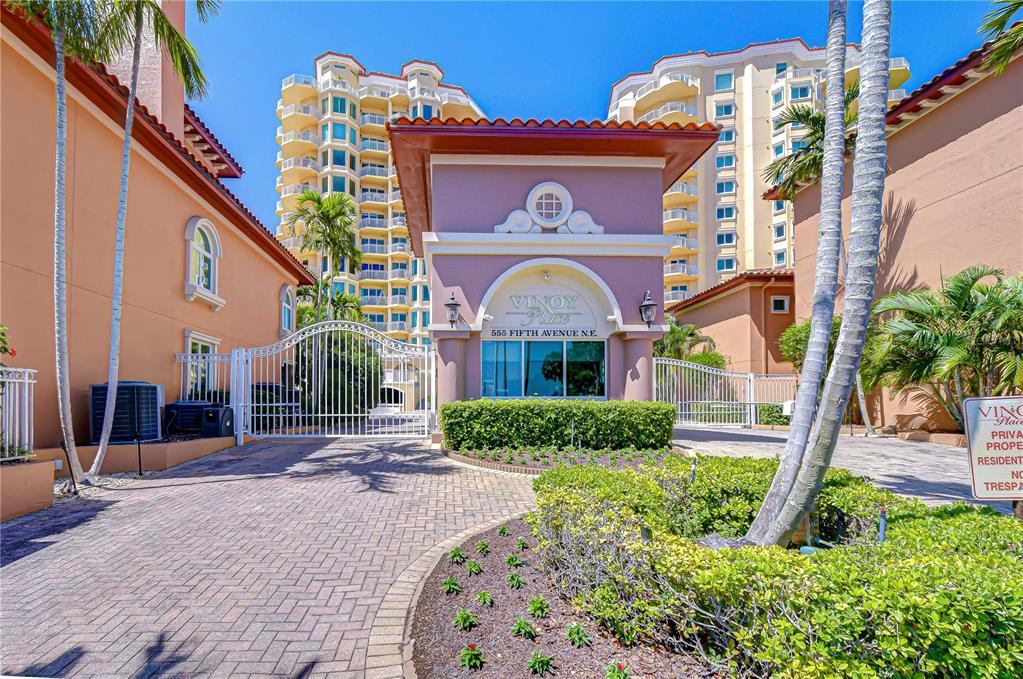 The gated entrance to a residential complex features a decorative archway and paved driveway — 555 5TH AVENUE NE UNIT 711, ST PETERSBURG, FL