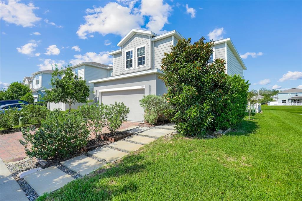 A two-story house with light gray siding, a garage, and a stone walkway — 4347 SILVER CREEK STREET, KISSIMMEE, FL