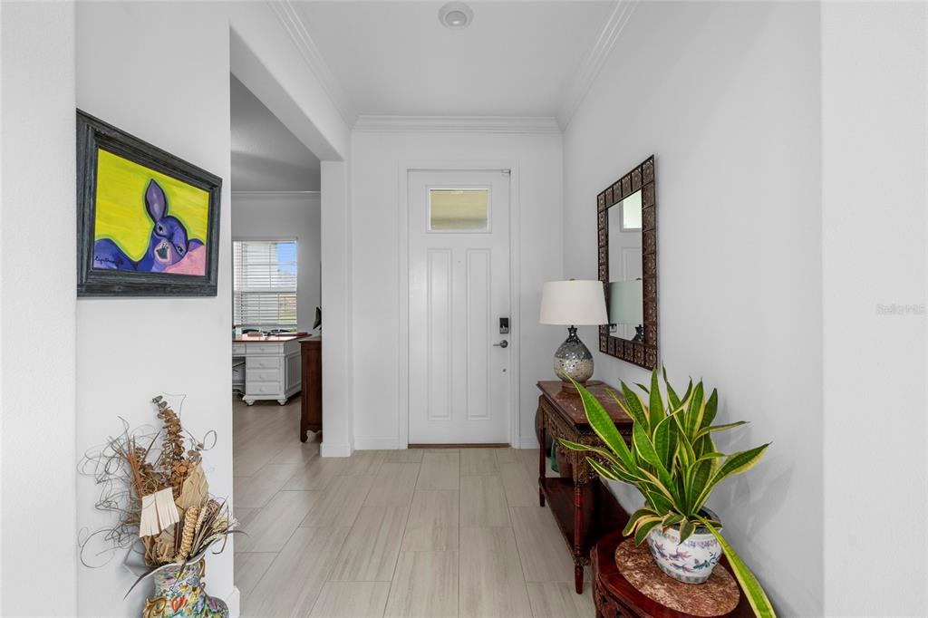 A bright entryway features a white front door, tile flooring, and a console table — 12657 TAHITIAN PEARL CIRCLE, PARRISH, FL