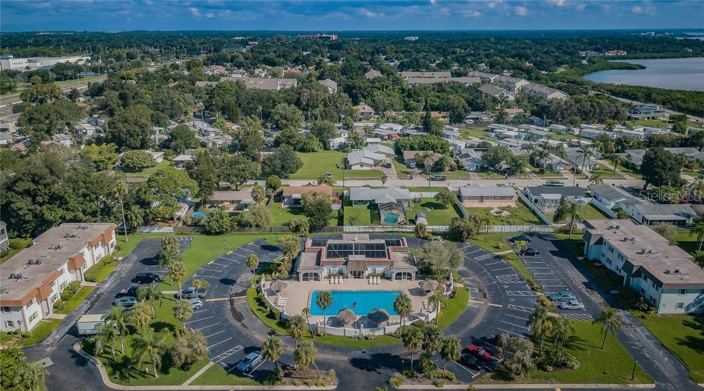 An aerial view shows a community swimming pool surrounded by a parking lot and buildings — 383 S MCMULLEN BOOTH ROAD UNIT 68, CLEARWATER, FL