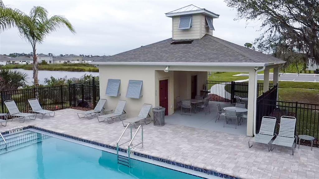 An outdoor swimming pool area features a covered pavilion with lounge chairs and patio tables — 2704 GOLDEN TROUT LANE, EDGEWATER, FL