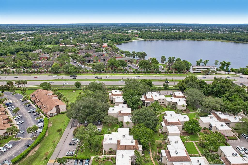 An aerial view shows a residential apartment complex with a lake and a highway nearby — 3252 S SEMORAN BOULEVARD UNIT 22, ORLANDO, FL