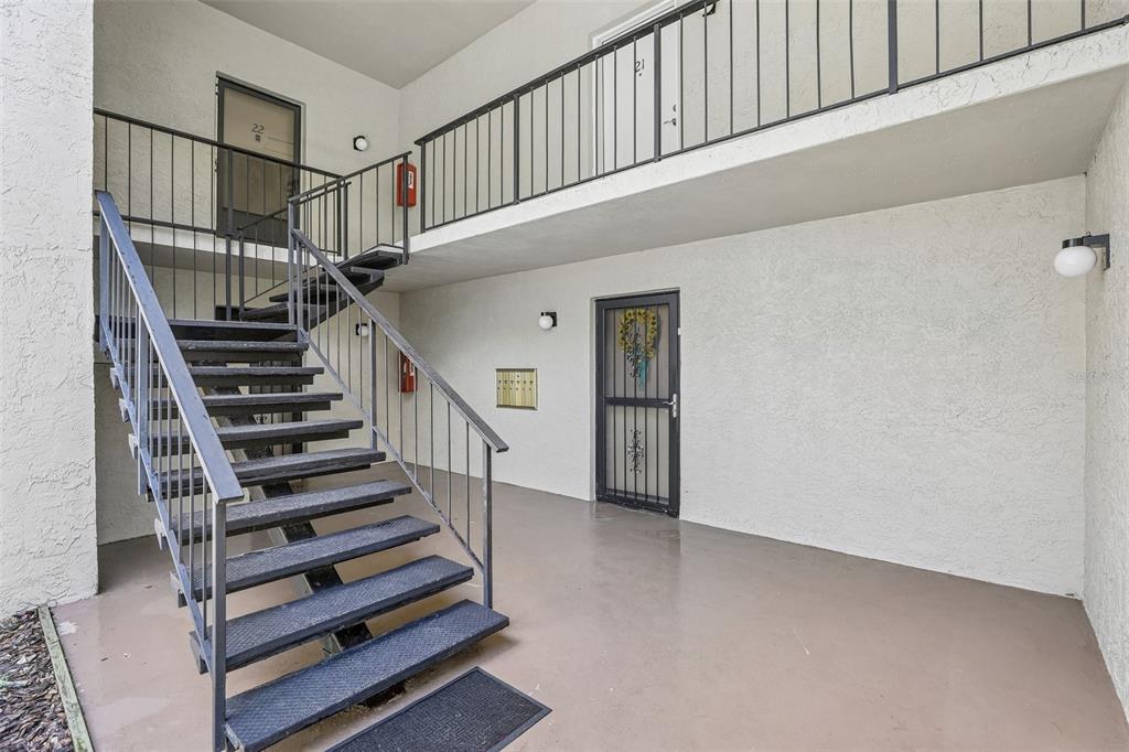 An outdoor staircase leads to an upper-level walkway with metal railings and apartment entry doors — 3252 S SEMORAN BOULEVARD UNIT 22, ORLANDO, FL
