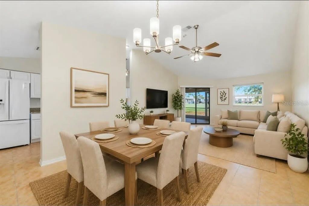 An open-concept living and dining area with tile floors, a chandelier, and a ceiling fan — 1203 SAXONY CIRCLE UNIT C, PUNTA GORDA, FL