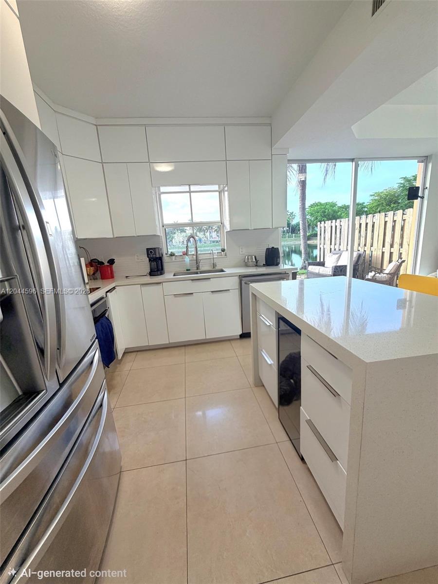A modern kitchen features white cabinetry, a quartz island, stainless steel appliances, and tile flooring — 11405 NW 62nd Ter # 236, Doral FL 33178, DORAL, FL