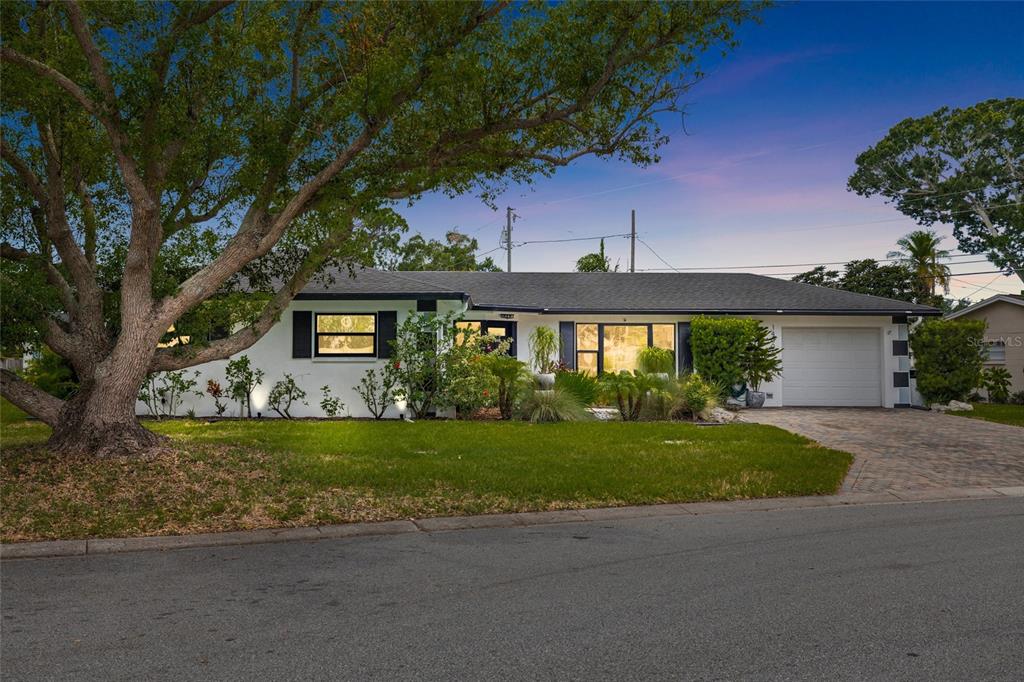 A white single-story house with a garage and a large tree in the front yard — 14006 81ST AVENUE, SEMINOLE, FL