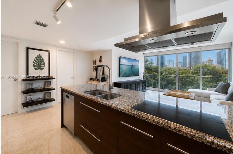A modern kitchen features a granite island with a cooktop, dark cabinetry, and floor-to-ceiling windows — 495 Brickell Ave # 411, Miami FL 33131, MIAMI, FL