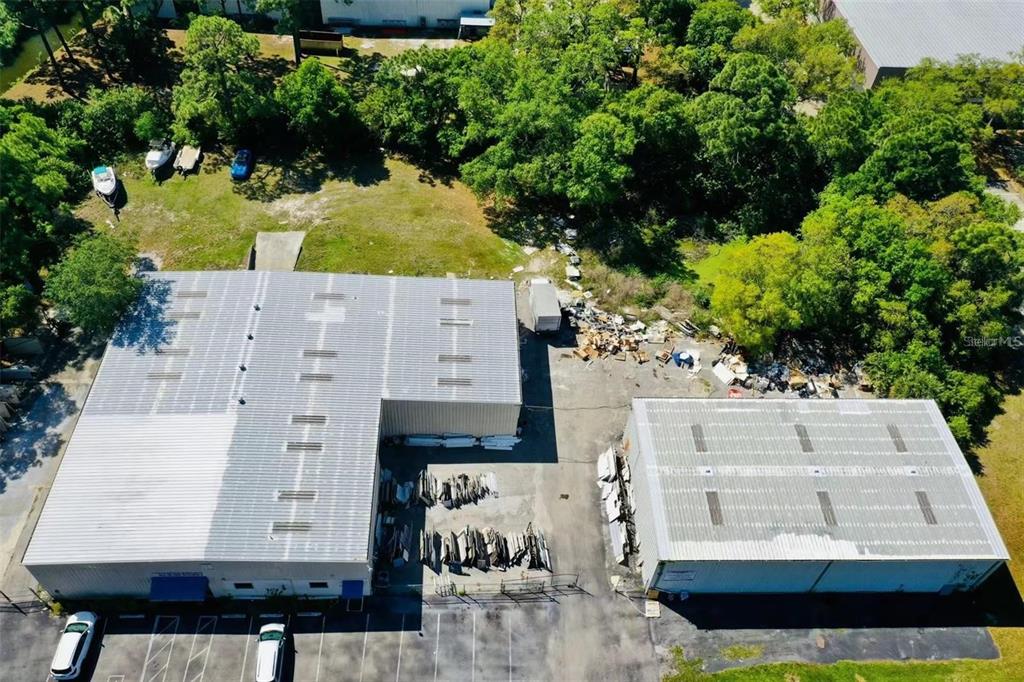 An aerial view shows two industrial warehouse buildings with parking and outdoor storage areas — 2398 63RD AVENUE E, BRADENTON, FL