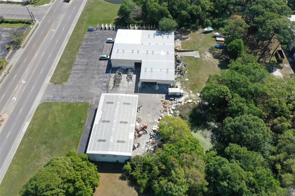An aerial view shows two industrial warehouse buildings with adjacent parking and outdoor storage areas — 2398 63RD AVENUE E, BRADENTON, FL