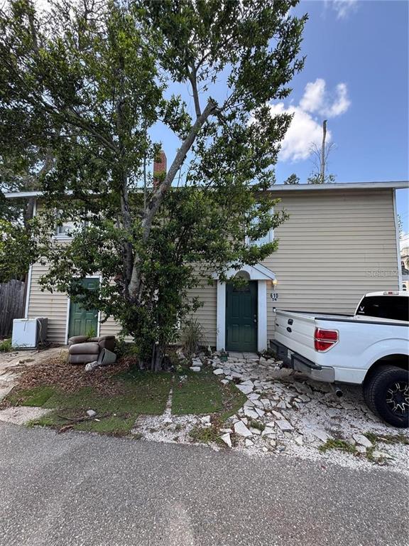 A two-story house with beige siding, a green front door, and a white pickup truck — 610 21ST STREET W, BRADENTON, FL