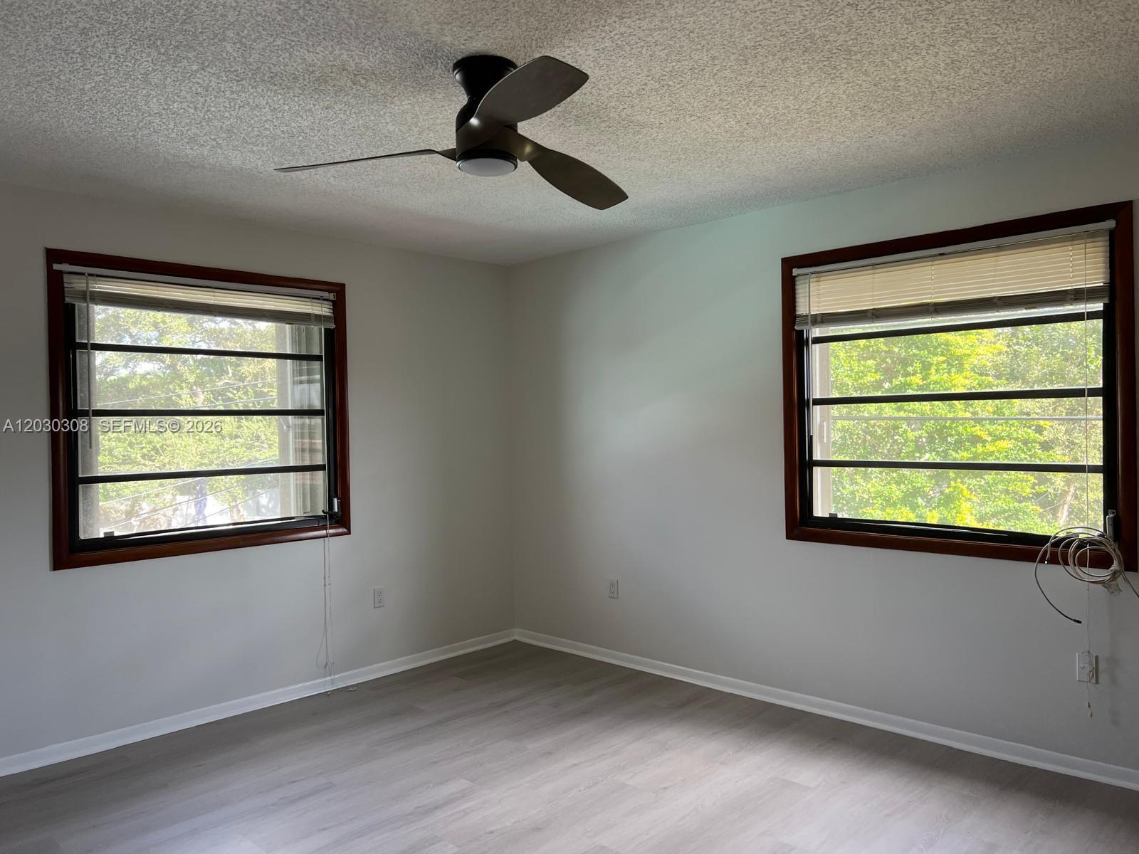An empty bedroom features light gray flooring, white walls, a ceiling fan, and two windows — 321 SW 71st Ave # 2, Miami FL 33144, MIAMI, FL