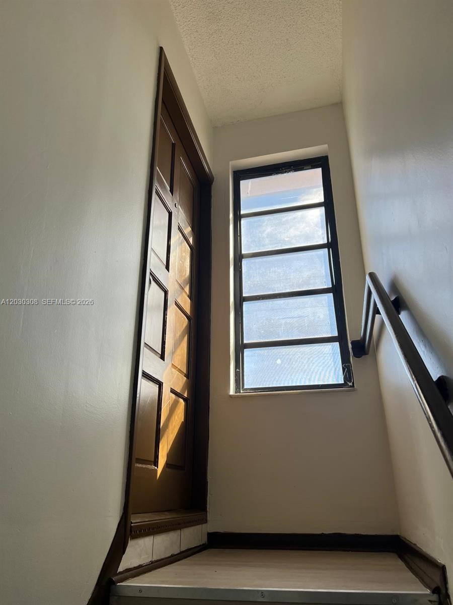 A wooden door and a window with horizontal panes are located at the top of stairs — 321 SW 71st Ave # 2, Miami FL 33144, MIAMI, FL