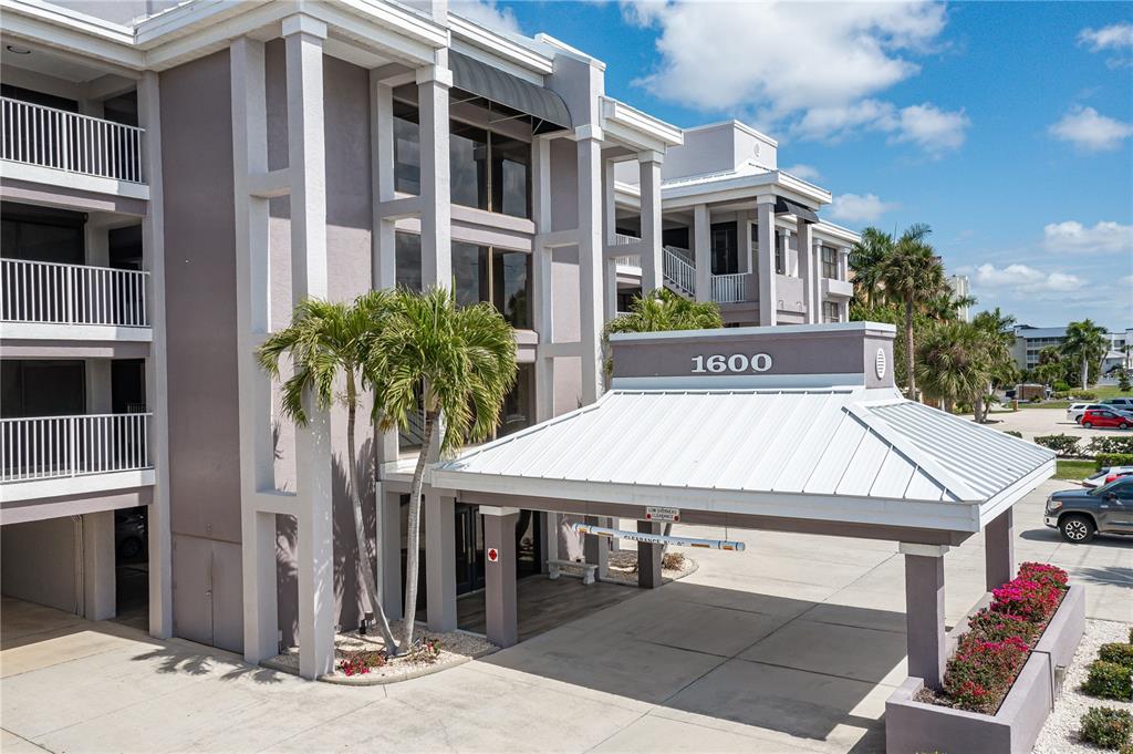 A multi-story apartment building features a covered entrance with the number 1600 displayed — 1600 W MARION AVENUE UNIT 234, PUNTA GORDA, FL