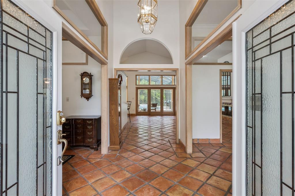 An entryway with terracotta tile floors leads to a living area with glass patio doors — 381 CREEKSTONE COURT, LONGWOOD, FL
