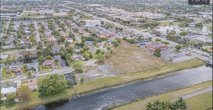 An aerial view shows a vacant lot situated between a residential neighborhood and a canal — 3900 NW 37TH STREET, LAUDERDALE LAKES, FL