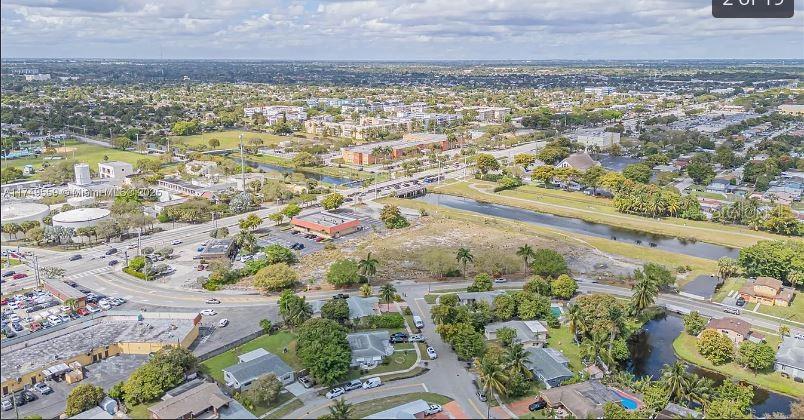 An aerial view shows a suburban neighborhood with a canal, roads, and commercial buildings — 3900 NW 37TH STREET, LAUDERDALE LAKES, FL
