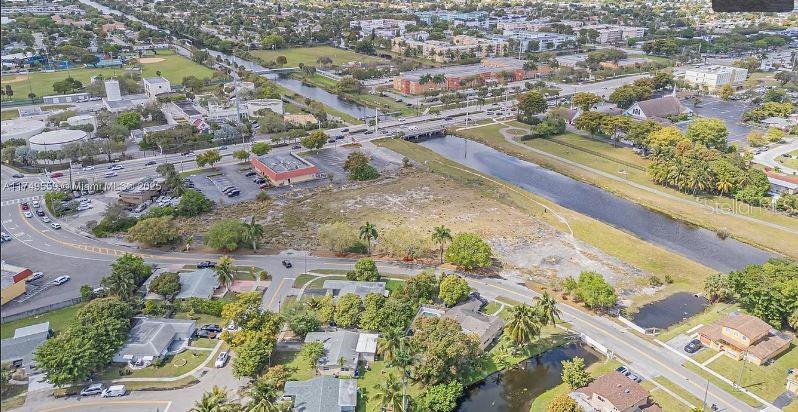 An aerial view shows a vacant lot situated between a canal and residential streets — 3900 NW 37TH STREET, LAUDERDALE LAKES, FL