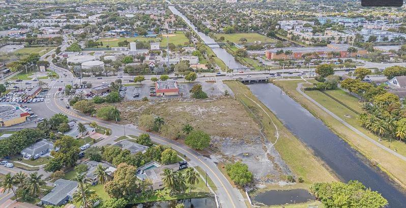 An aerial view shows a vacant lot situated between a residential neighborhood and a canal — 3900 NW 37TH STREET, LAUDERDALE LAKES, FL