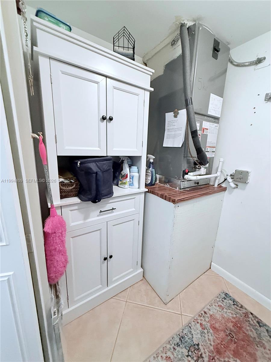 A utility closet contains a white cabinet, a pink duster, and an HVAC unit — 340 Pine Ridge Cir # 1, Green Acres FL 33463, GREEN ACRES, FL