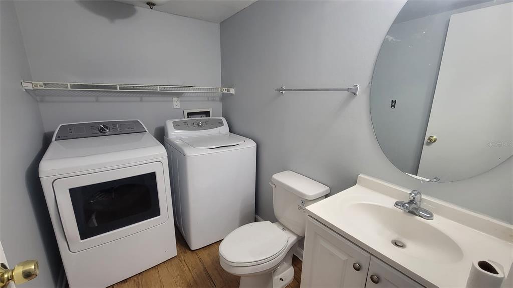 A laundry room featuring a washer, dryer, toilet, and vanity with a mirror — 4410 SHADOW CREST PLACE UNIT 41-2, ORLANDO, FL