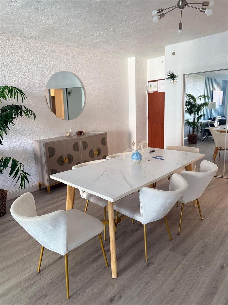 A dining room features a white marble-topped table, six white chairs, and a grey sideboard — 4001 S Ocean Drive # 7k, Hollywood FL 33019, HOLLYWOOD, FL