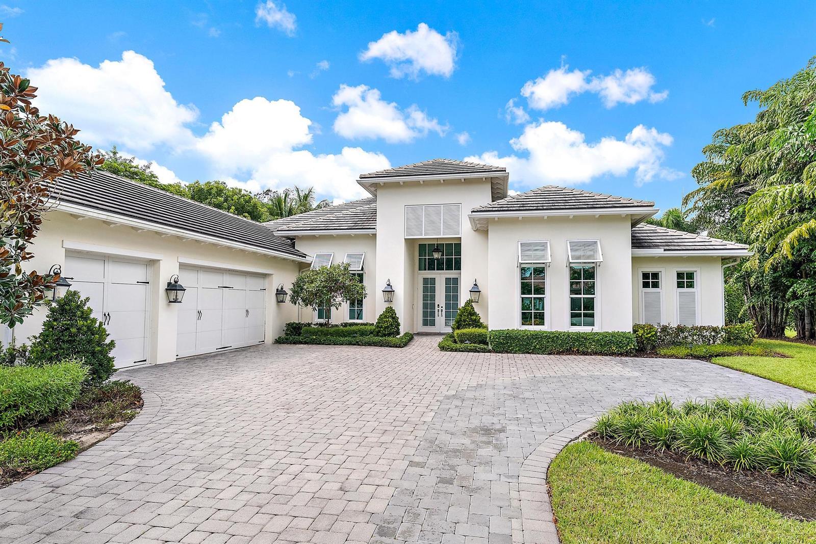 A single-story white house with a paved driveway, a three-car garage, and a tiled roof — 6081 Wildcat Run, West Palm Beach FL 33412, WEST PALM BEACH, FL