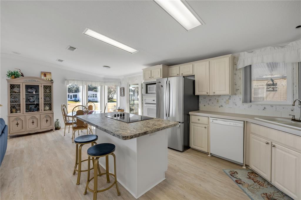 A kitchen with a central island, stainless steel appliances, and light-colored cabinetry — 290 NAVAJO DRIVE, OAK HILL, FL