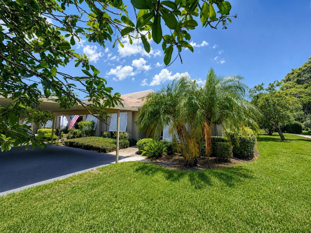 A single-story house with a carport, white shutters, and a palm tree on a lawn — 5530 37TH STREET E, BRADENTON, FL