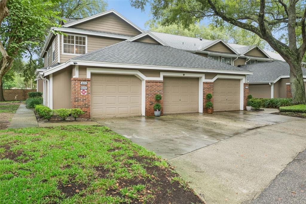 A multi-unit residential building with three tan garage doors and brick accents on the exterior — 683 POST OAK CIRCLE UNIT 105, ALTAMONTE SPRINGS, FL