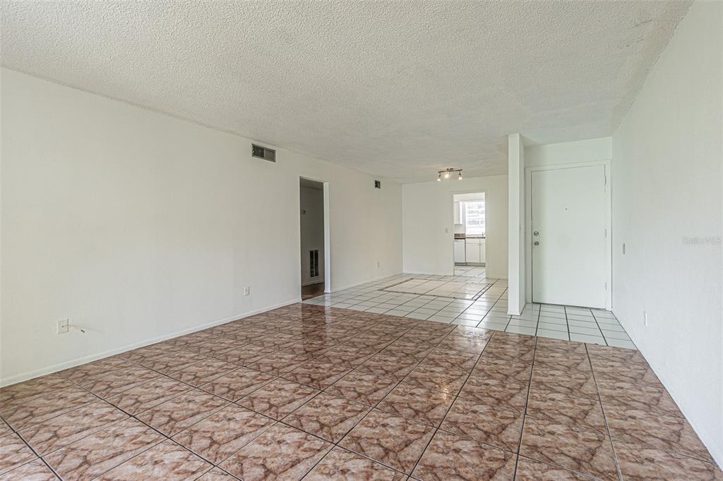 An interior view of a living area with brown patterned tile flooring and white walls — 7517 ABONADO ROAD UNIT 7517, TAMPA, FL