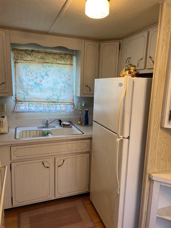 A kitchen features white cabinets, a double-basin sink, and a white refrigerator — 12674 SEMINOLE BOULEVARD UNIT M1, LARGO, FL