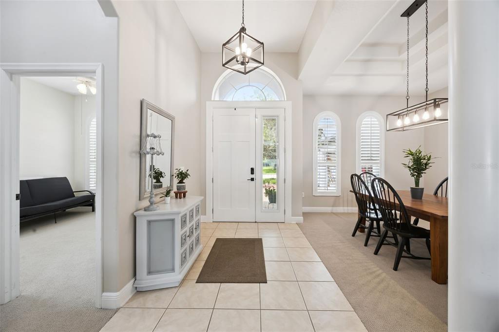 A bright entryway features tiled floors, a white front door, and an adjacent dining area — 3121 JUNEBERRY TERRACE, OVIEDO, FL