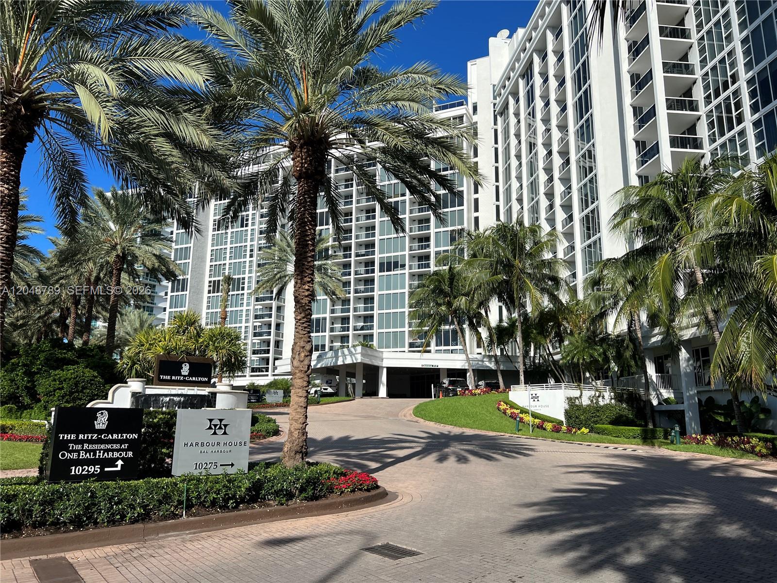 A paved driveway leads to the entrance of a large white residential building with palm trees — 10275 Collins Ave # 112, Bal Harbour FL 33154, BAL HARBOUR, FL
