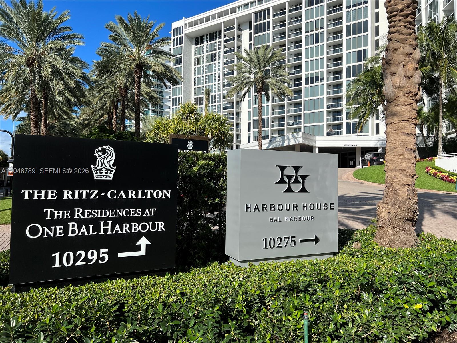 Two signs for residential buildings stand in front of a tall white apartment complex — 10275 Collins Ave # 112, Bal Harbour FL 33154, BAL HARBOUR, FL