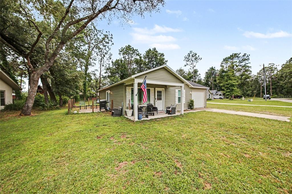 A single-story house with light green siding, a front porch, and an attached garage — 17050 SE 60TH STREET, OCKLAWAHA, FL