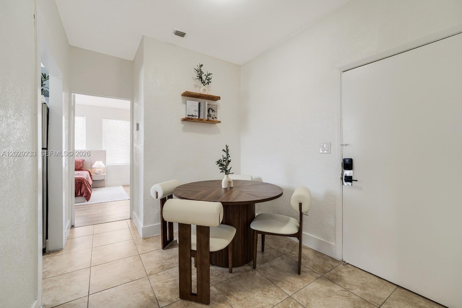 A dining area features a round wooden table with four chairs on a tiled floor — 301 SW 10th Ave # 7, Miami FL 33130, MIAMI, FL