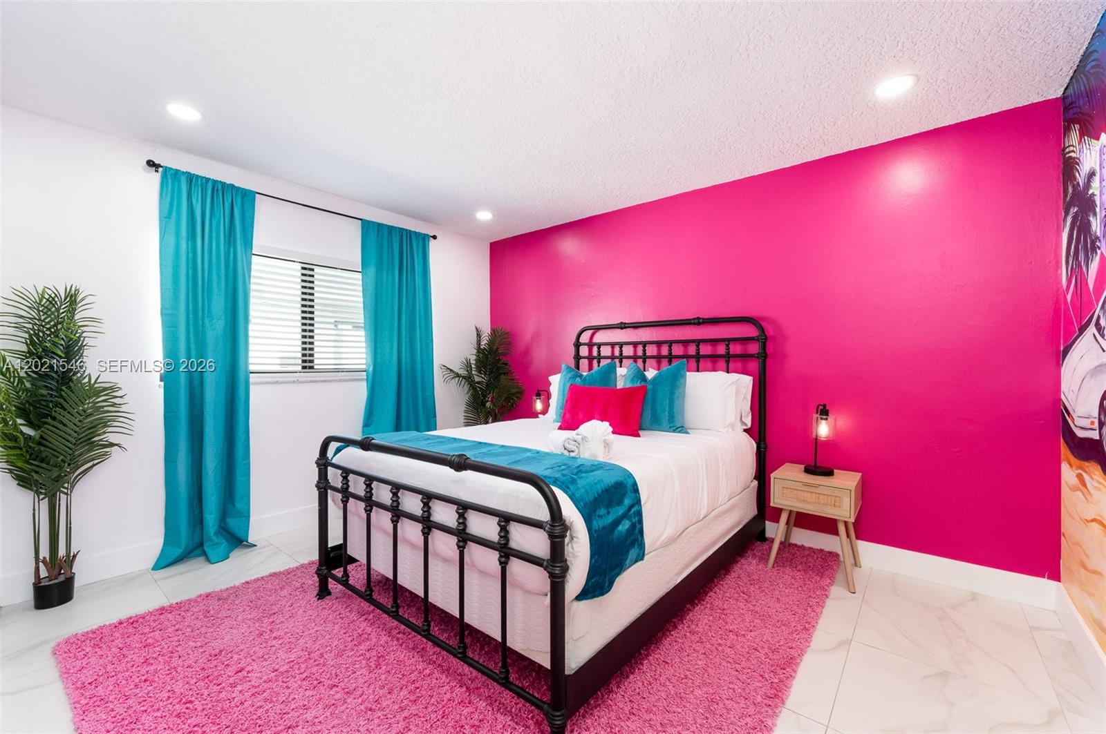A bedroom features a bright pink accent wall, a black metal bed, and teal curtains — 329 SE 12th Ave # 2, Pompano Beach FL 33060, POMPANO BEACH, FL