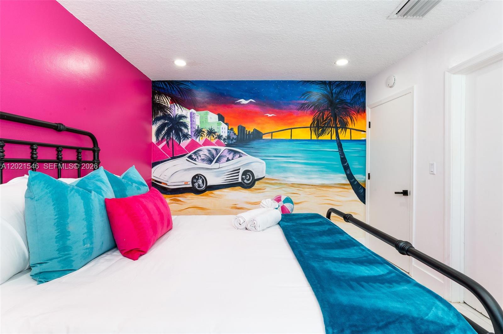 A bedroom features a vibrant mural of a beach scene and a hot pink wall — 329 SE 12th Ave # 2, Pompano Beach FL 33060, POMPANO BEACH, FL