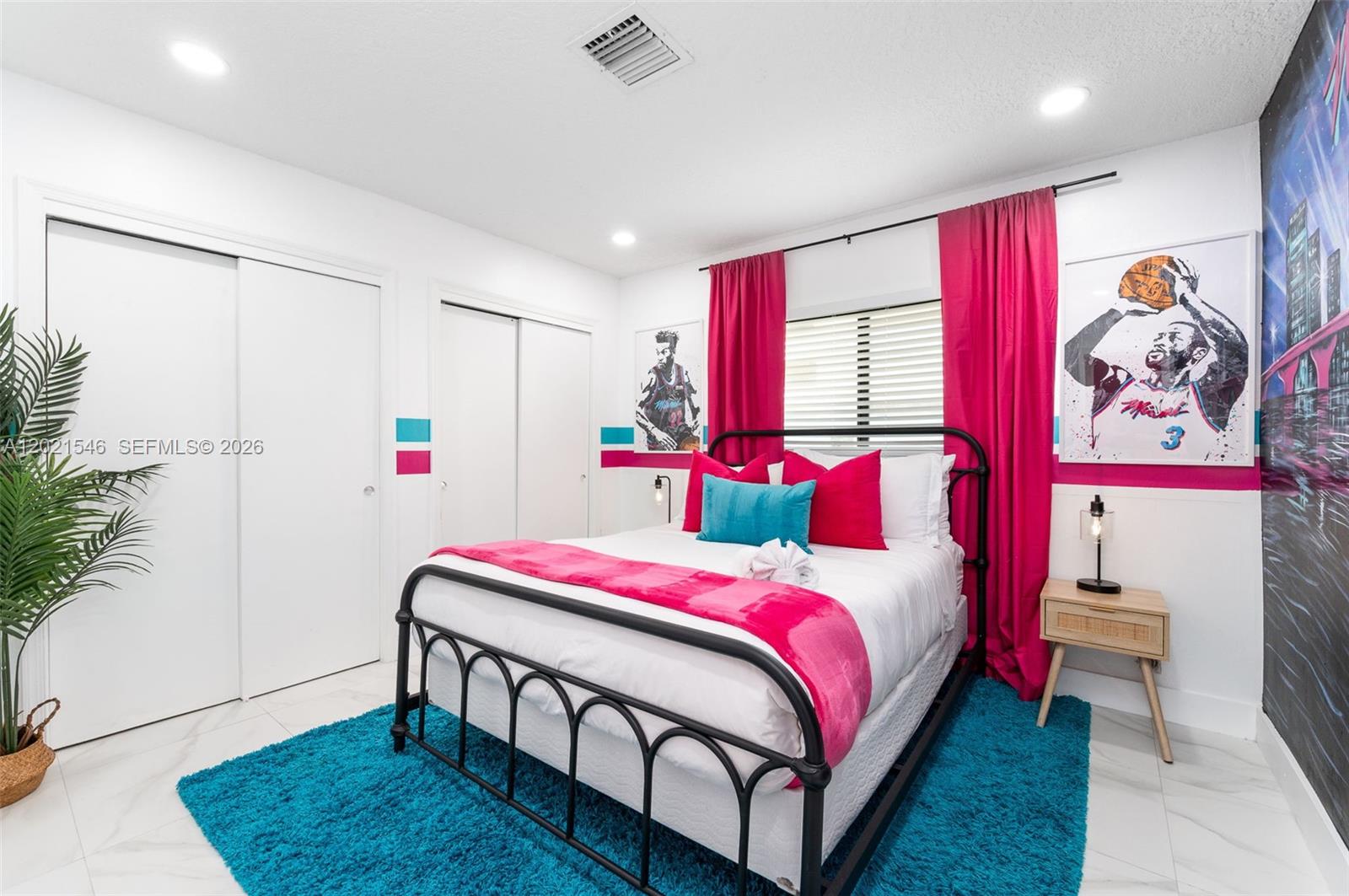 A bedroom features a black metal bed frame, bright pink curtains, and Miami Heat-themed decor — 329 SE 12th Ave # 2, Pompano Beach FL 33060, POMPANO BEACH, FL