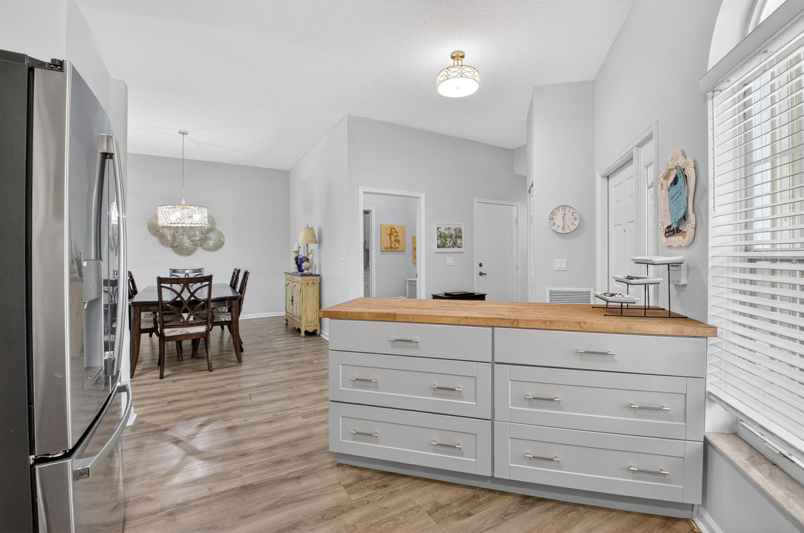 A kitchen island with a wood countertop sits in a room with light gray walls — 8446 Vía Serena, Boca Raton FL 33433, BOCA RATON, FL