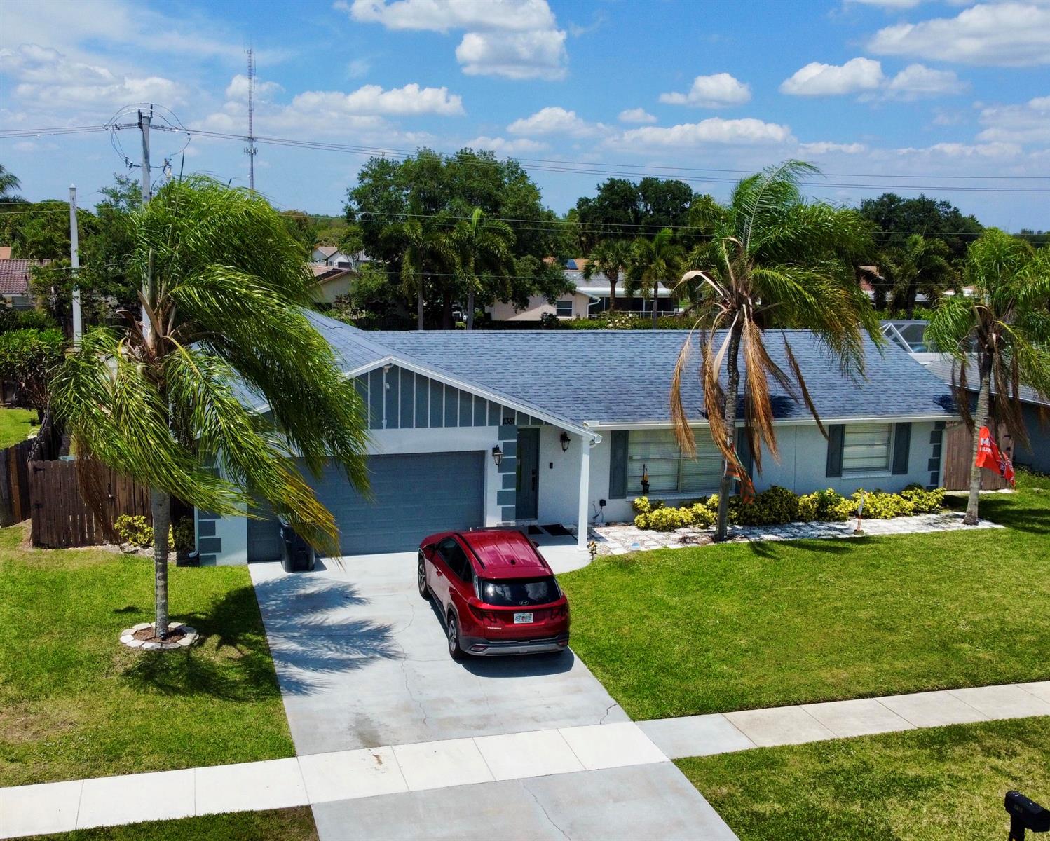 A living room features a stone fireplace wall, a large sectional sofa, and a chandelier — 1381 Wyndcliff, Wellington FL 33414, WELLINGTON, FL