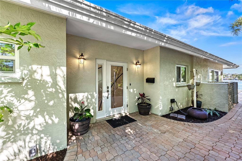 The exterior of a house features a paved patio, a front door, and two sconces — 1320 MOONMIST DRIVE UNIT B-11, SARASOTA, FL