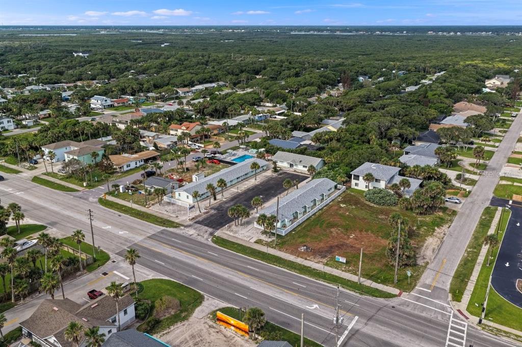 This aerial view shows a property with two long buildings, a pool, and parking areas — 1708 S ATLANTIC AVENUE, NEW SMYRNA BEACH, FL