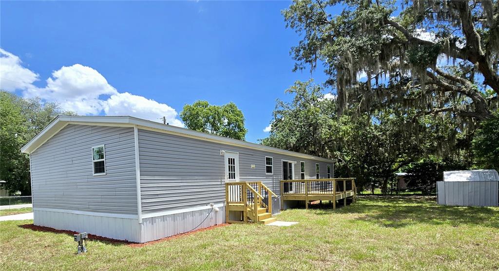 An aerial view shows a single-story home with a concrete driveway and a small carport — 659 ALPINE STREET, MASCOTTE, FL