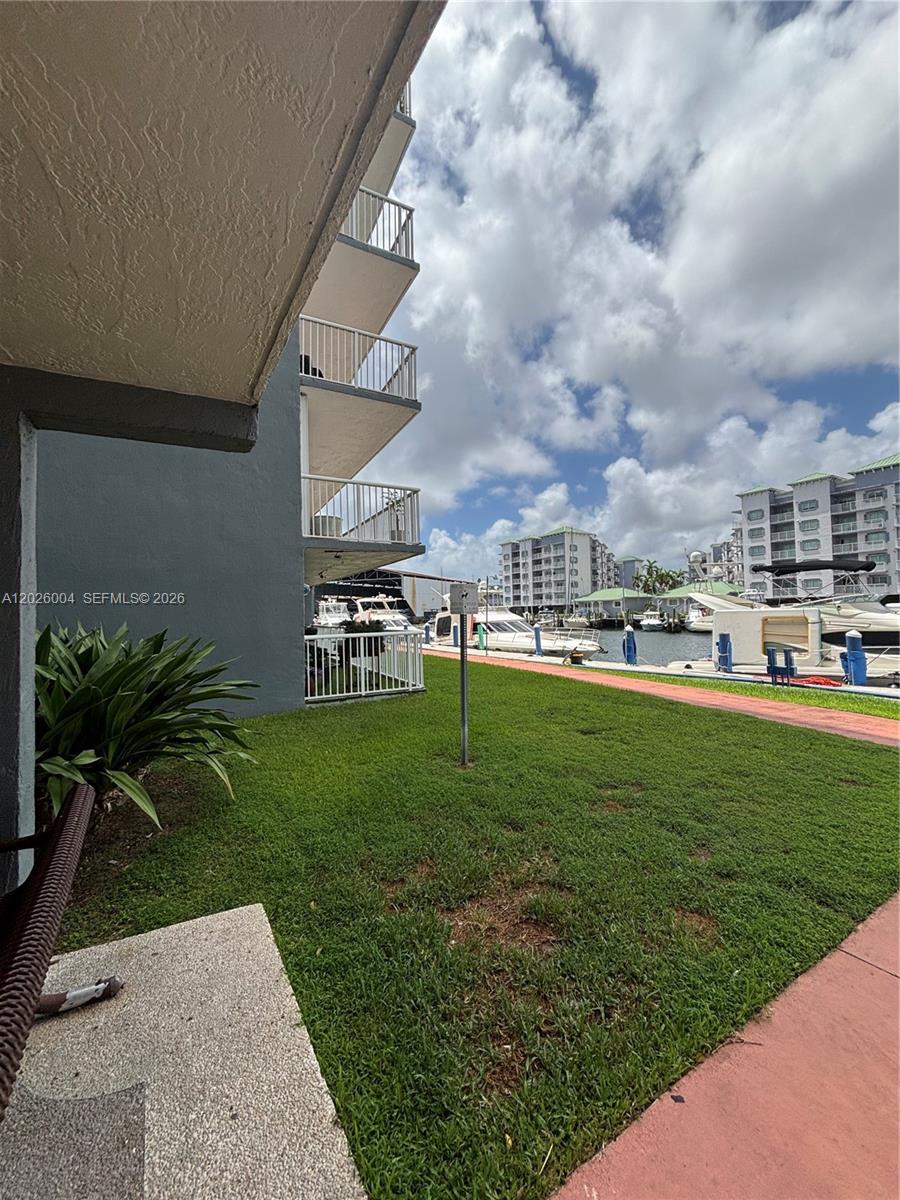 A view of a grassy lawn, a building exterior, and a marina with docked boats — 1800 NW 24th Ave # 314, Miami FL 33125, MIAMI, FL